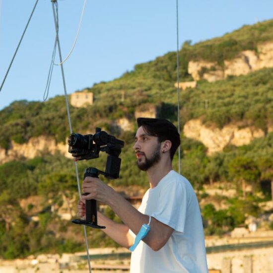 Vacation Photographer taking a couple in video. Boat in Sorrento Coast with beautiful sunset