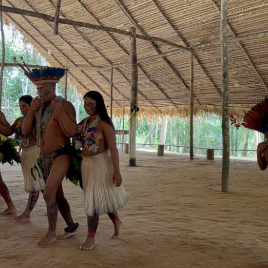 indigeni brasiliani che suonano e ballano all'interno di un villaggio